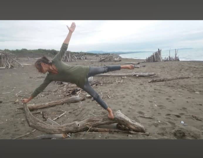 Chiara in una posizione yoga su una spiaggia